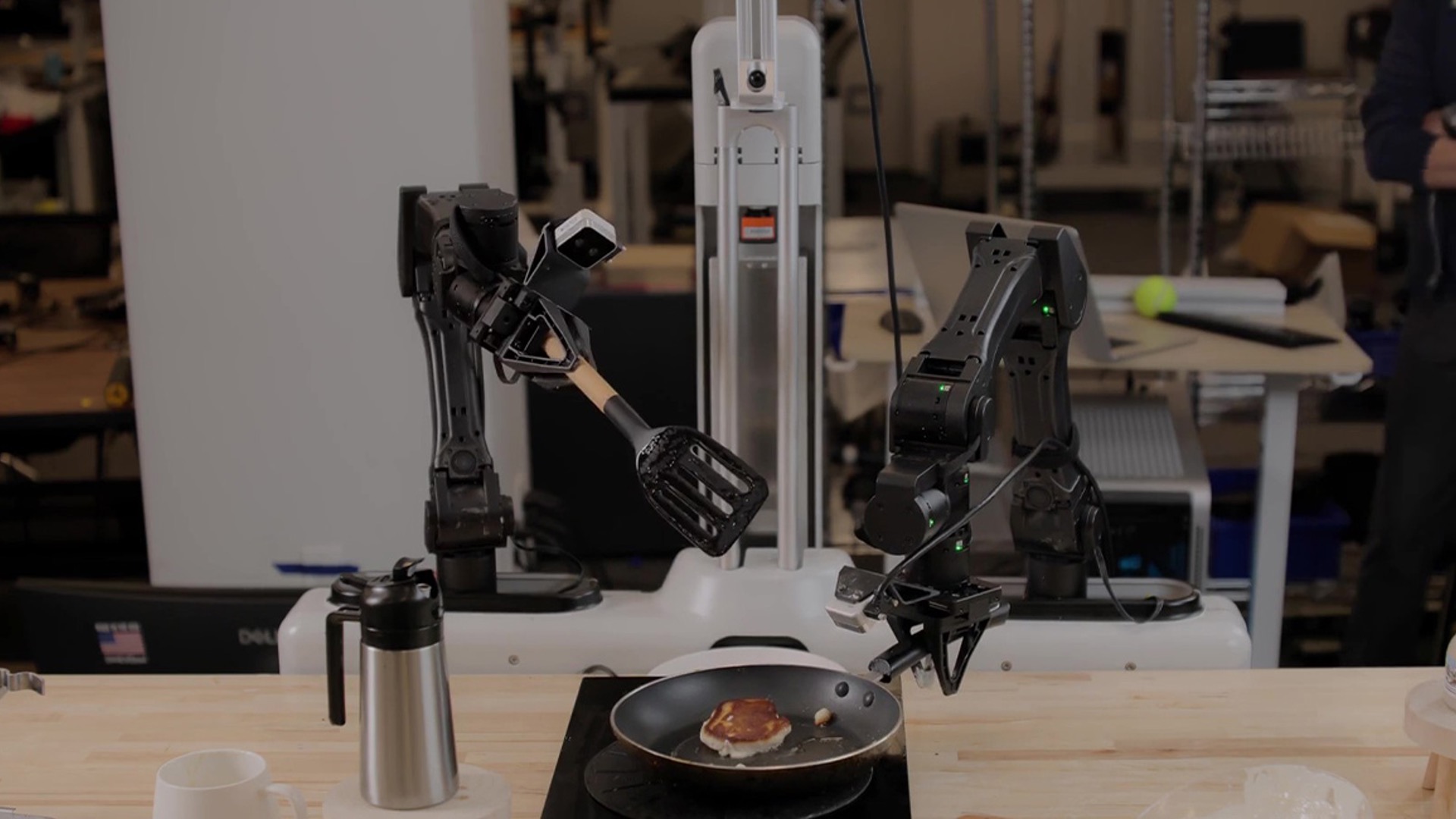 Skild AI's dual-arm robot flipping a pancake in a kitchen demo, from Nvidia's post on the S1 model